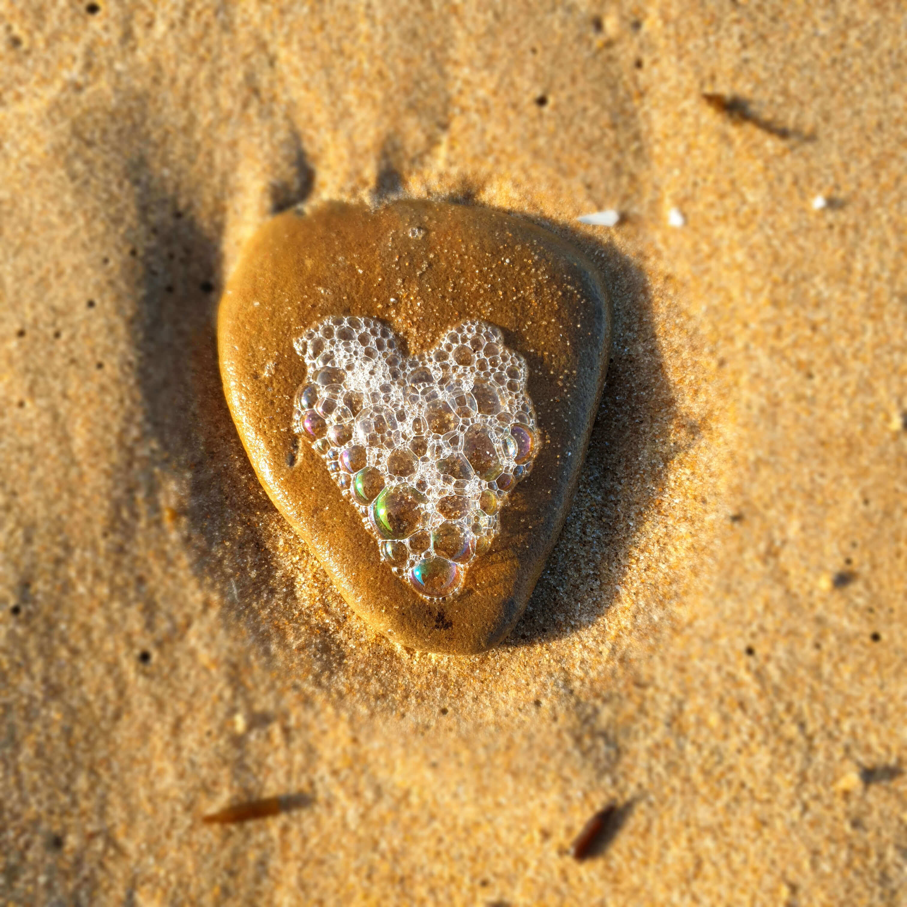Cœur formé par des bulles d'eau de mer et une pierre marron